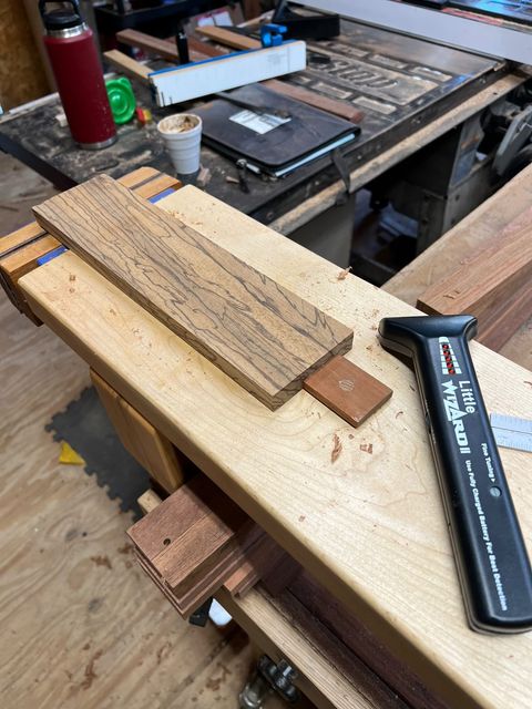 Little Wizard 2.5 metal detector on a woodworking bench next to a piece of spalted lumber in a real working shop
