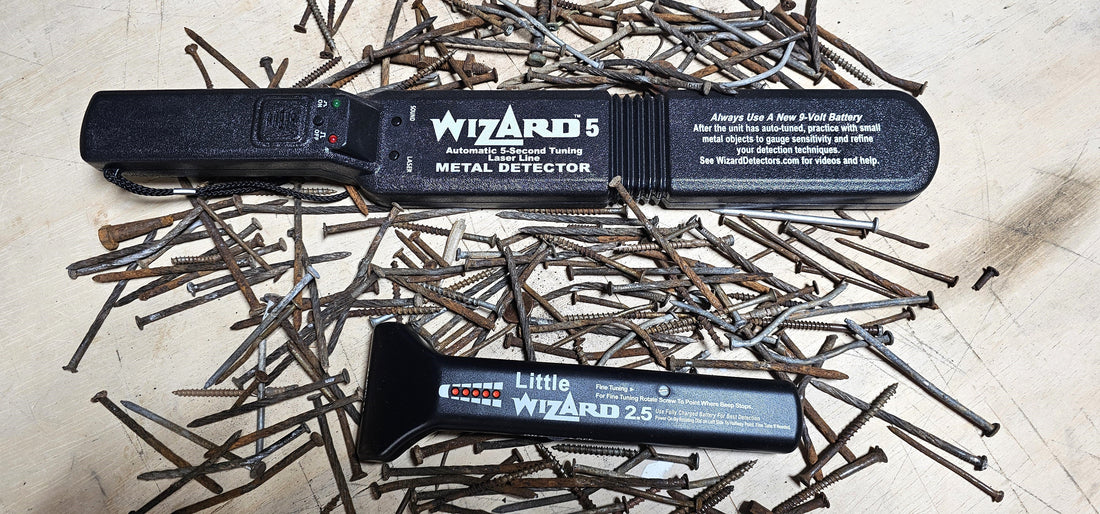Wizard 5 and Little Wizard 2.5 woodworking metal detectors surrounded by rusty nails on a workbench